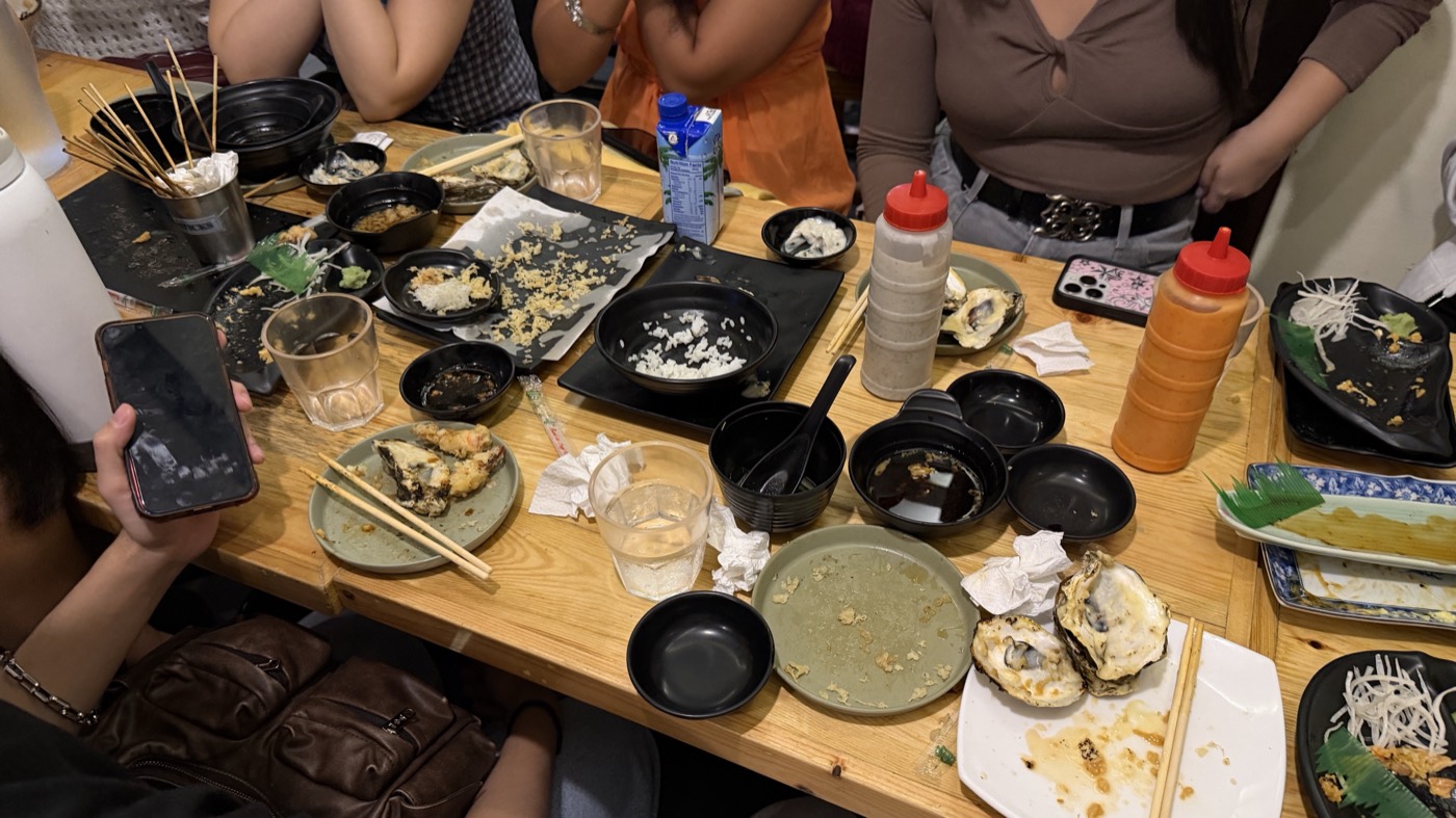 The aftermath of the day-two lunch: a long table covered in emptied plates, bowls, and oyster shells